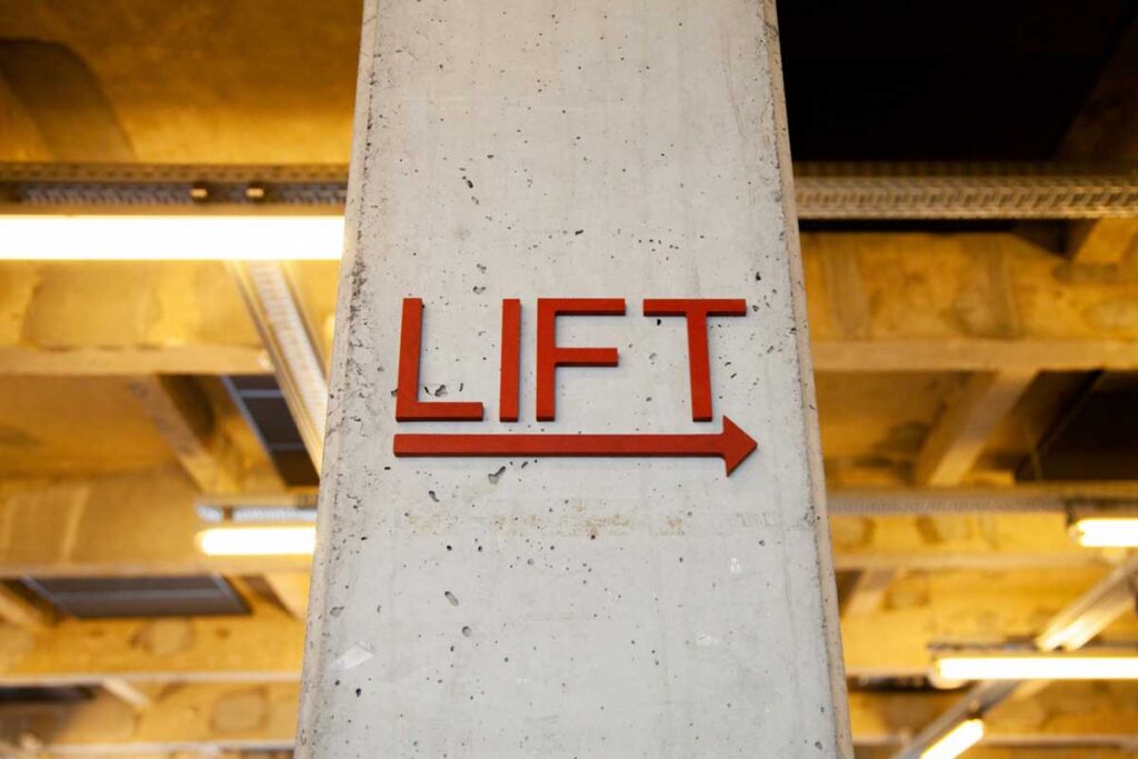 lift arrow direction sign on concrete pillar