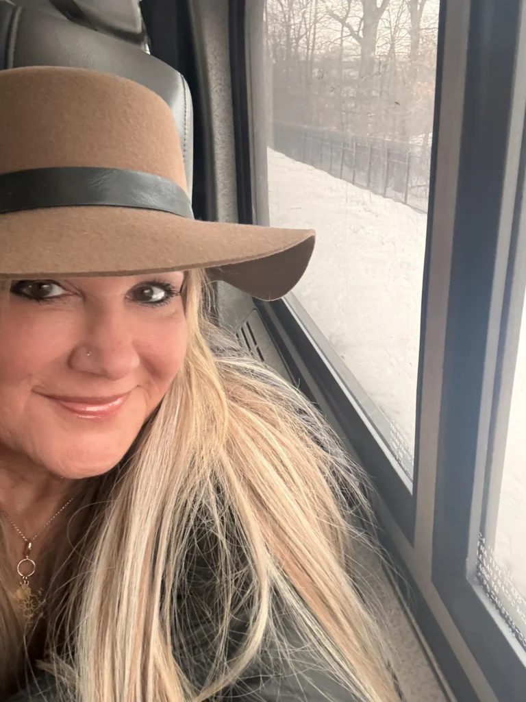 Brenda Viola on Train wearing a brimmed hat